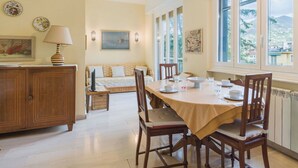 Un coin repas avec une table dressée pour quatre personnes, un canapé et une vue sur l’extérieur.