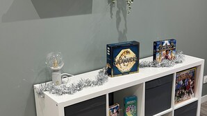 A white console table with a glass vase, a pair of red and black slippers, and two board games. - Maison des Volcans - 3 double bedrooms - 2 bathrooms - Patio - Wifi (Ceyrat)