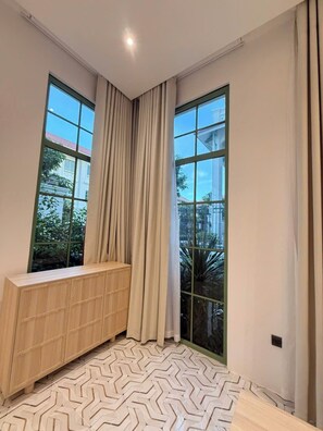 A room with large windows, a wooden cabinet, and a patterned floor. - Green Villas Tropical Phu Quoc (Phu Quoc)