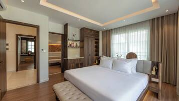 Quarto de hotel moderno com uma cama grande, um banco embutido, uma toucador com espelho e um closet espaçoso.