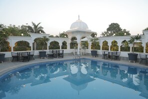 A pool with a white gazebo and seating area, surrounded by greenery. - Veer Garh Farms (Udaipur)