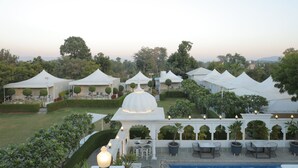 A garden area with white tents and a pool. - Veer Garh Farms (Udaipur)