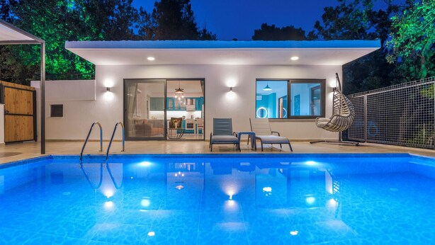 A modern pool area with a clear view of the pool, lounge chairs, and a covered patio. - Swim, Sauna, Sea: An Exclusive Forest Sanctuary with Mediterranean Panoramas (antalya)