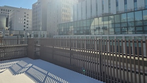 Un edificio moderno con ventanas grandes y una valla de madera al frente.