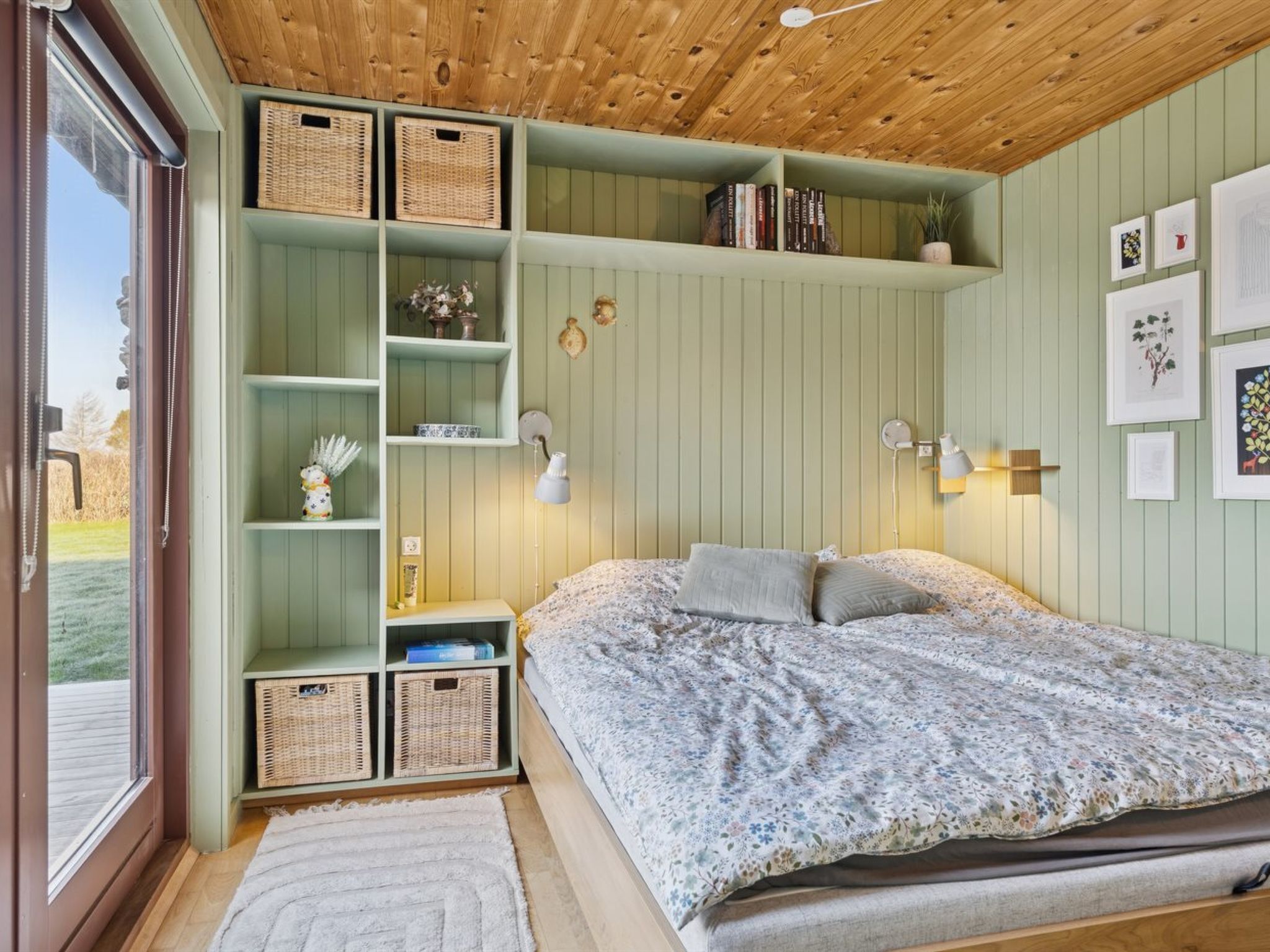 Una camera da letto con un letto, una parete verde, un soffitto in legno e una finestra.