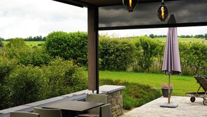 Un patio al aire libre con una mesa, sillas, una planta en maceta y una carretilla.