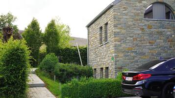 Un edificio de piedra con un camino empedrado y un coche estacionado.