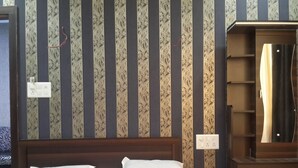 Een hotelkamer met een bed, een houten hoofdeinde, een kledingkast en een spiegel.