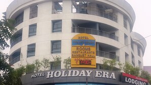 Een hotel genaamd "Holiday Era" met een bord waarop staat dat het kamers, een restaurant en een feestzaal biedt.