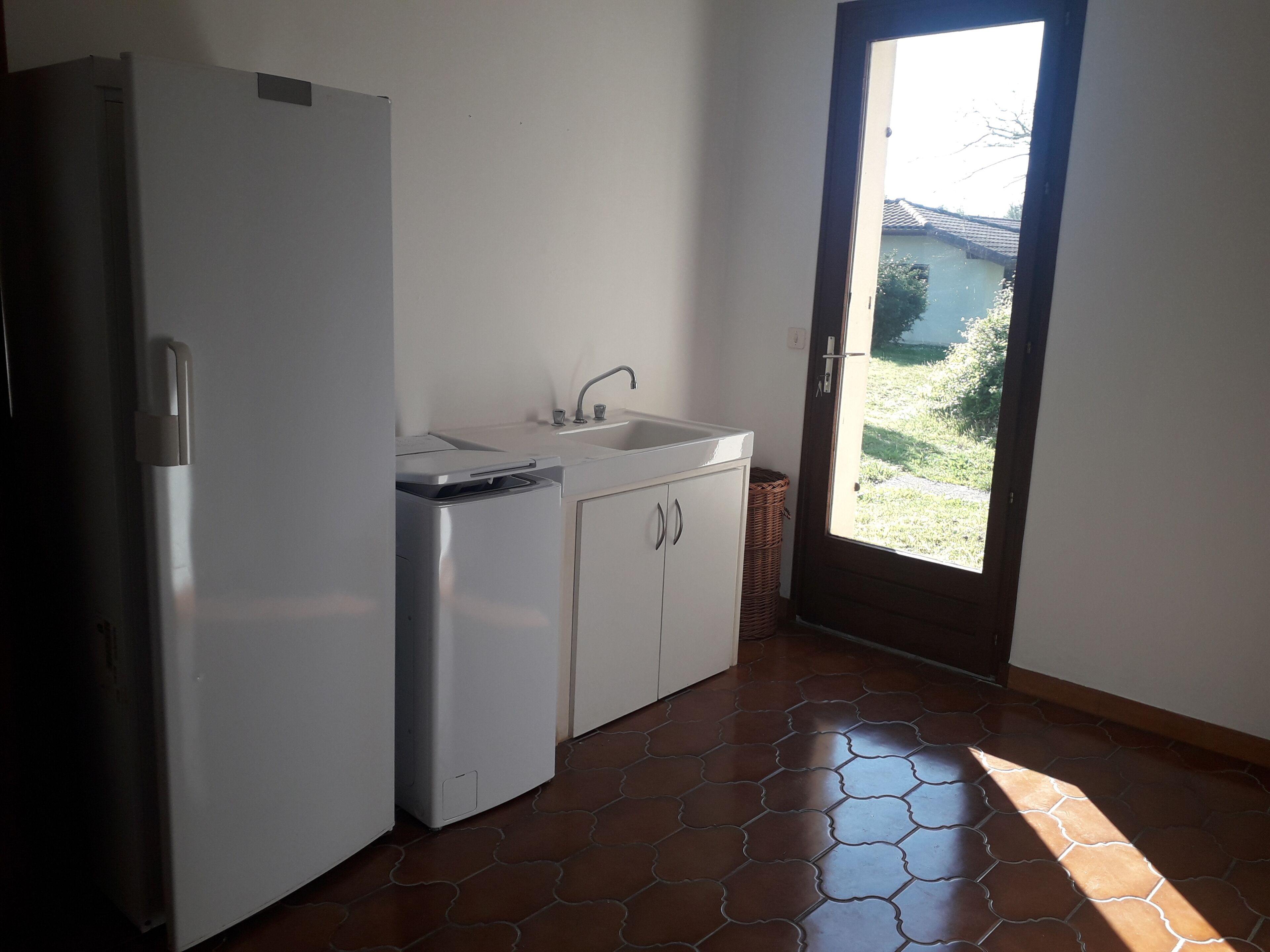 Eine Küche mit Kühlschrank, Spüle und Schränken.