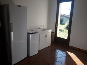 Cuina amb nevera, rentavaixelles i armaris.