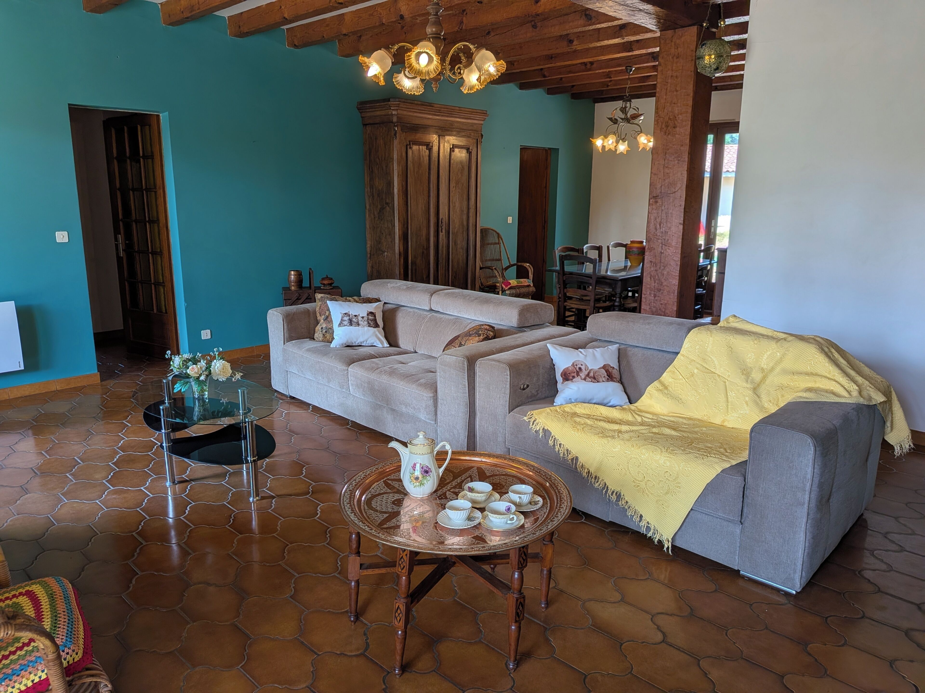 Una sala de estar con un conjunto de sofá, una mesita de centro con tazas de té y una alfombra estampada.