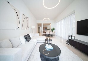 Ein modernes Wohnzimmer mit einer Couch, einem Couchtisch und einem Fernseher.