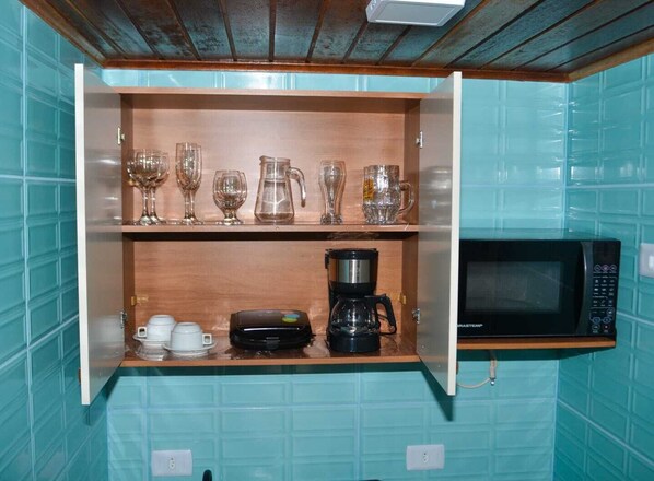 Een minikoelkast, een microgolfoven, een kookplaat, een waterkoker