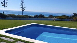 Una piscina amb vista despejada a l'oceà al fons.