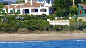 Una propietat costanera amb un edifici blanc caracteritzat per arcs múltiples i un teulat de teules vermelles.