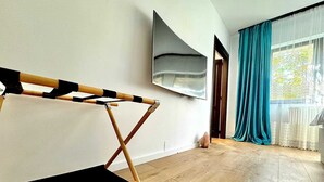 A modern room with a ballet barre, a large abstract painting, and a view of a cityscape through a window with teal curtains. - 3 Baneasa Airport (Bucharest)