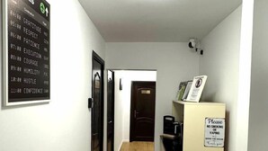 A hallway with a sign listing values like gratitude and courage, a microwave, and a trash bin. - 3 Baneasa Airport (Bucharest)