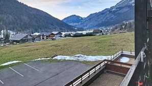 Ett bergigt landskap med utsikt över en byggnad med en balkong.