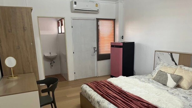 A bedroom with a bed, a desk, a chair, a wardrobe, and a bathroom. - PPplace Mahidol (Chiang Mai)
