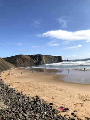 A beach with rocky foreground, a sandy shore, and cliffs in the background. - Pina Hideaway with a sea view rooftop terrace (Aljezur)