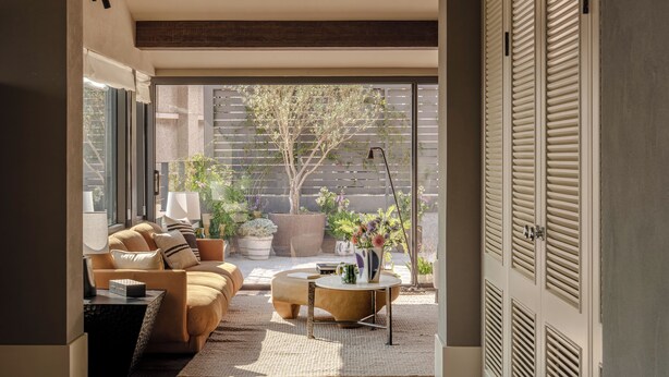 A modern living room with a sofa, coffee table, and potted plants. - Sunyata Mountain Alley Chongqing Resort (Chongqing)