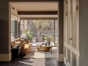 A modern living room with a sofa, coffee table, and potted plants. - Sunyata Mountain Alley Chongqing Resort (Chongqing)