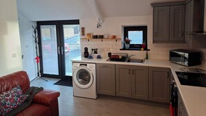 A compact kitchen with a washing machine, a microwave, and a small window. - Kintrae Cottage


Close to Game of Thrones Studio (Banbridge)