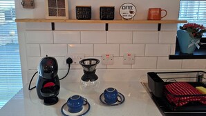 A kitchen with a coffee maker, a kettle, and a coffee-themed sign on the wall. - Kintrae Cottage


Close to Game of Thrones Studio (Banbridge)