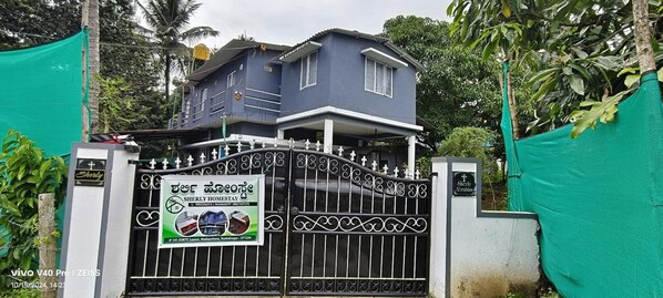 A gated property with a sign indicating a Sherly Homestay.