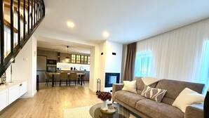A modern living room with a sofa, coffee table, and a dining area with chairs. - Villa Billubium-Authentic Stone Villa with Private Heated Pool (Lokvičići)