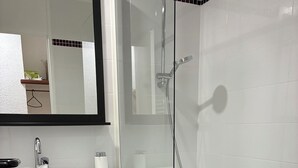 A modern bathroom with a white sink, mirror, and bathtub.