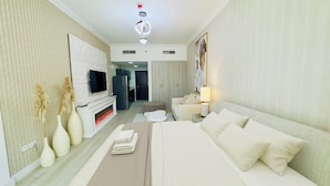 Ein modernes Hotelzimmer mit Sofa, Flachbildfernseher, Kamin und Essbereich.