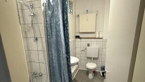 A bathroom with a shower, toilet, and sink.