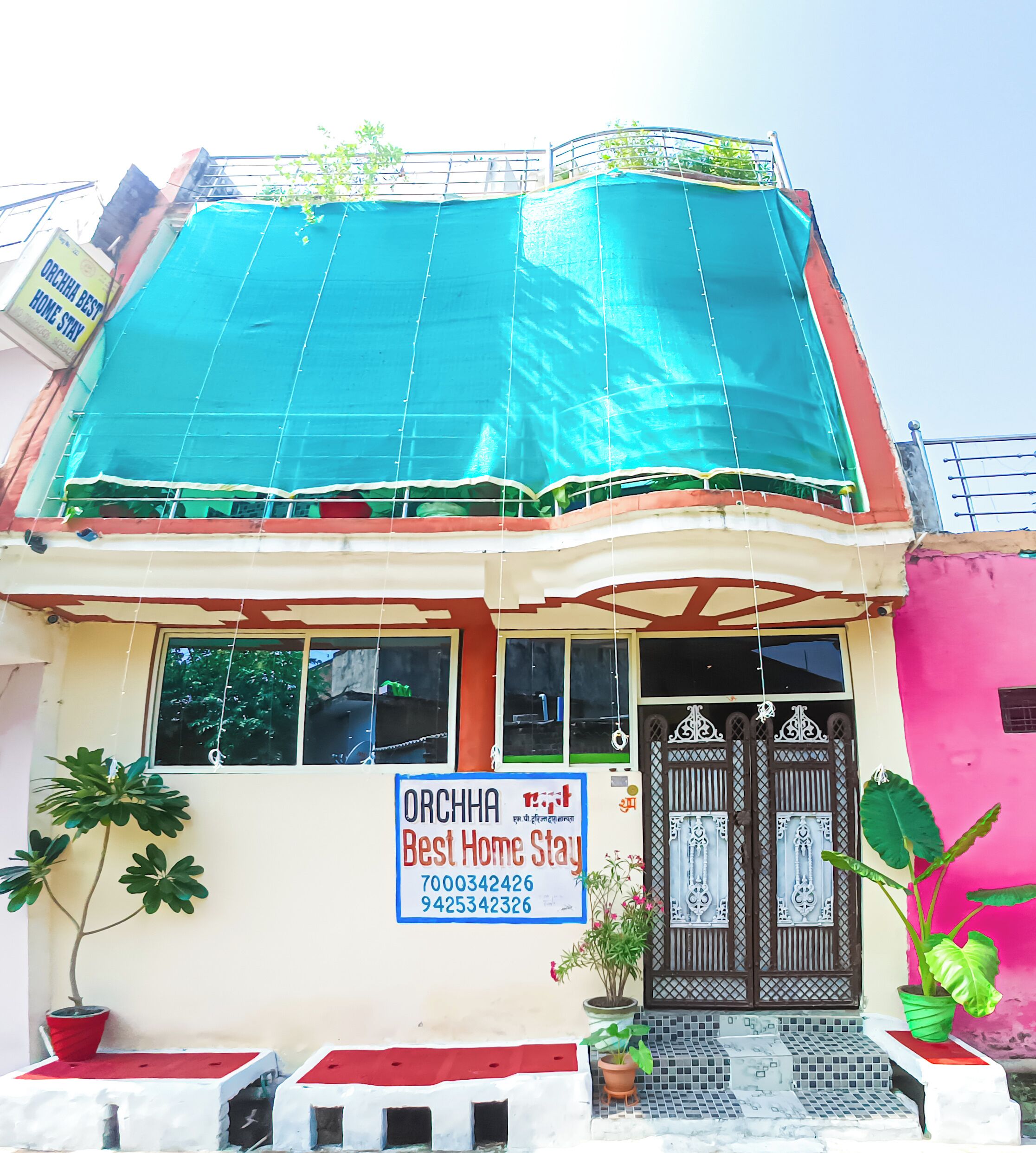 Et toetagers hus med et skilt, der reklamerer for 'Orchha Best Home Stay'.