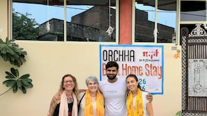 A group of people posing in front of a building with a sign that reads "Orchha Home Stay." - Orchha best homestay (Orchha)