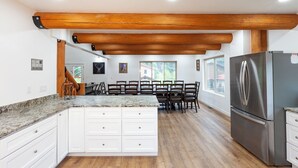 A kitchen with a central island, white cabinetry, a stainless steel refrigerator, and a wooden ceiling. - Almost Heaven - Newly Built! - In Town - On the River - WiFi - Grill - Mountain (Red River)