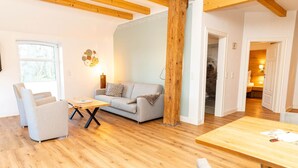 Ein gemütliches Wohnzimmer mit einer Couch, einem Sessel und einem Holztisch.