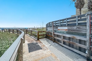 A wooden deck with a sign instructing to shower and remove sand before entering the pool. - Summer House unit 1005B 3br and 2ba Gulf Front in Orange Beach sleeps 8 (Orange Beach)