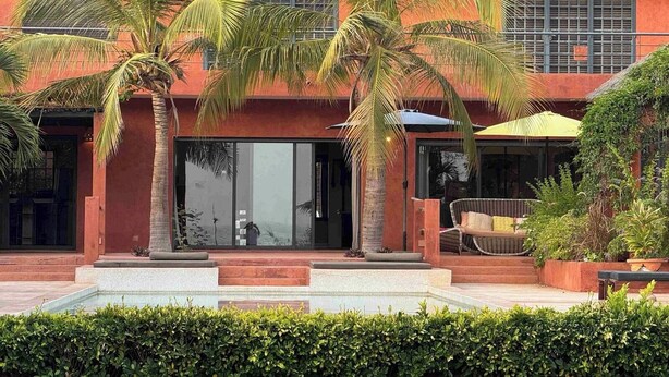 A resort with a thatched roof, palm trees, and a pool area. - Villa Terre et Océan  (Ngaparou)