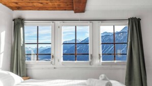 A room with a bed and a window with a mountain view. - Maison Historique de Charme à Mollens, 8 pers (Mollens)