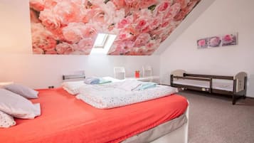 A bedroom with a bed, a desk, and a bunk bed.