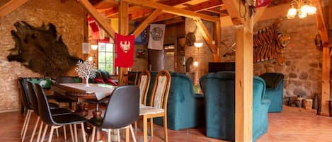 Un comedor rústico con mesa de madera, sillas y una araña.