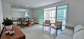 A modern living room with a sofa, chairs, a dining table, and a potted plant. - COALP0100 - Alphaville Residencial Lion (Salvador)