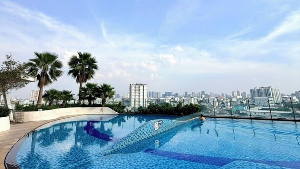 A rooftop pool with a cityscape view, surrounded by palm trees and a clear sky. - Sunrise High Floor Pool Ben Thanh Gym (Ho Chi Minh City)