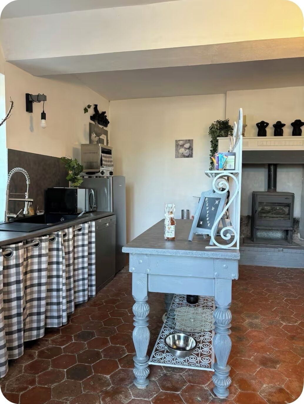 Une cuisine dotée d’un îlot central, d’un évier, d’une cuisinière et d’un coin repas avec une table et des chaises.