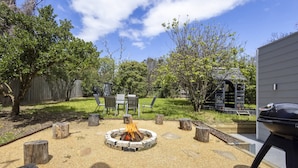 A backyard with a fire pit, outdoor furniture, and a barbecue grill. - Peaceful 2-bed Apartment in Coastal Mccrae (Melbourne)