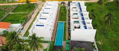 Un hotel con varias plantas, piscina y aparcamiento.