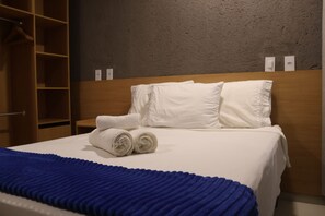 A hotel room with a neatly made bed, a blue blanket, and a wooden headboard. - MHV Milagres - Manah B 212 &  B 211  (São Miguel dos Milagres)