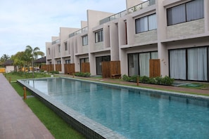 A modern hotel with a swimming pool, multiple balconies, and a well-maintained garden area. - MHV Milagres - Manah B 212 & B 211 (São Miguel dos Milagres)